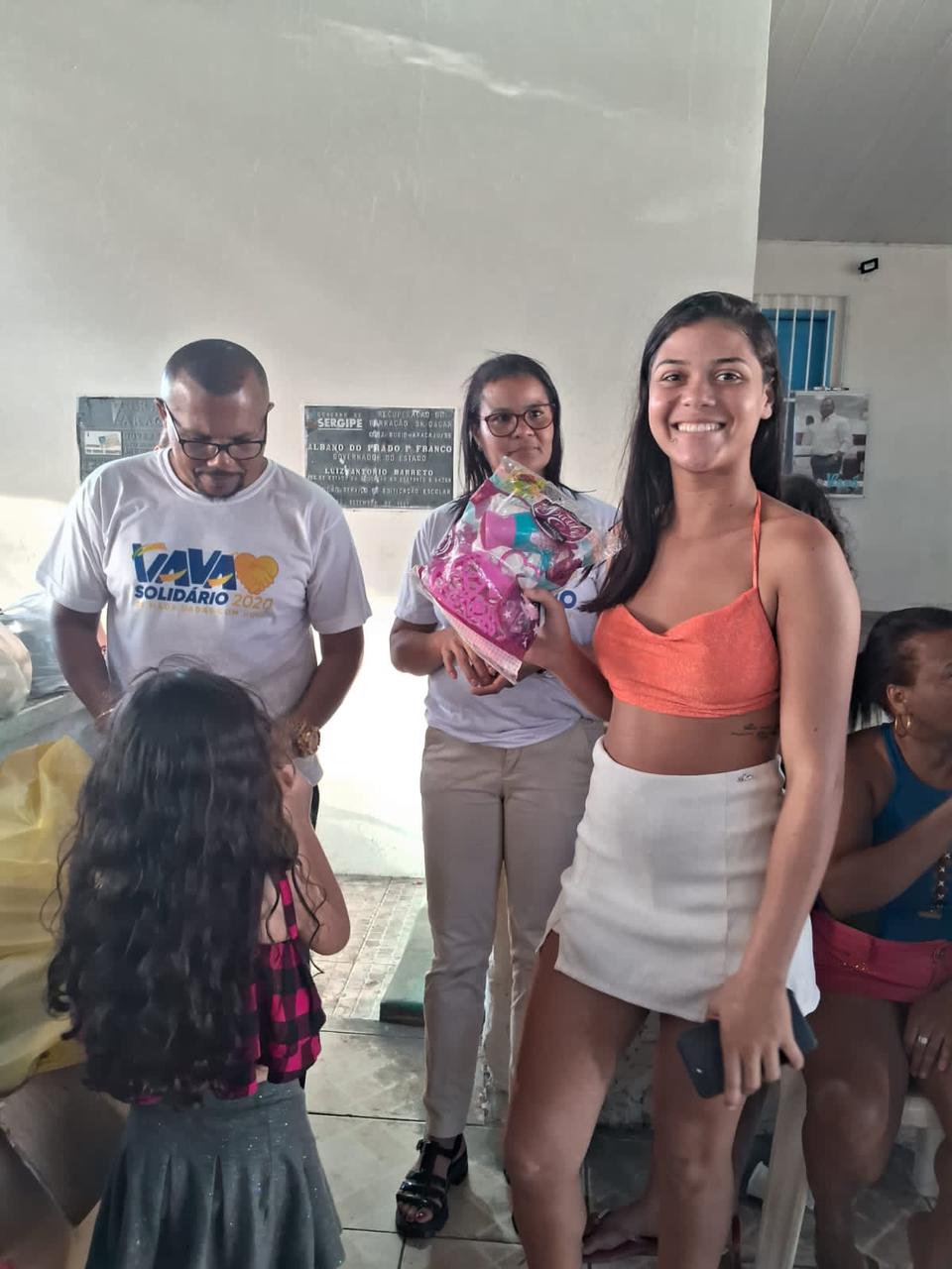 Família mostra o presente recebido durante a ação
