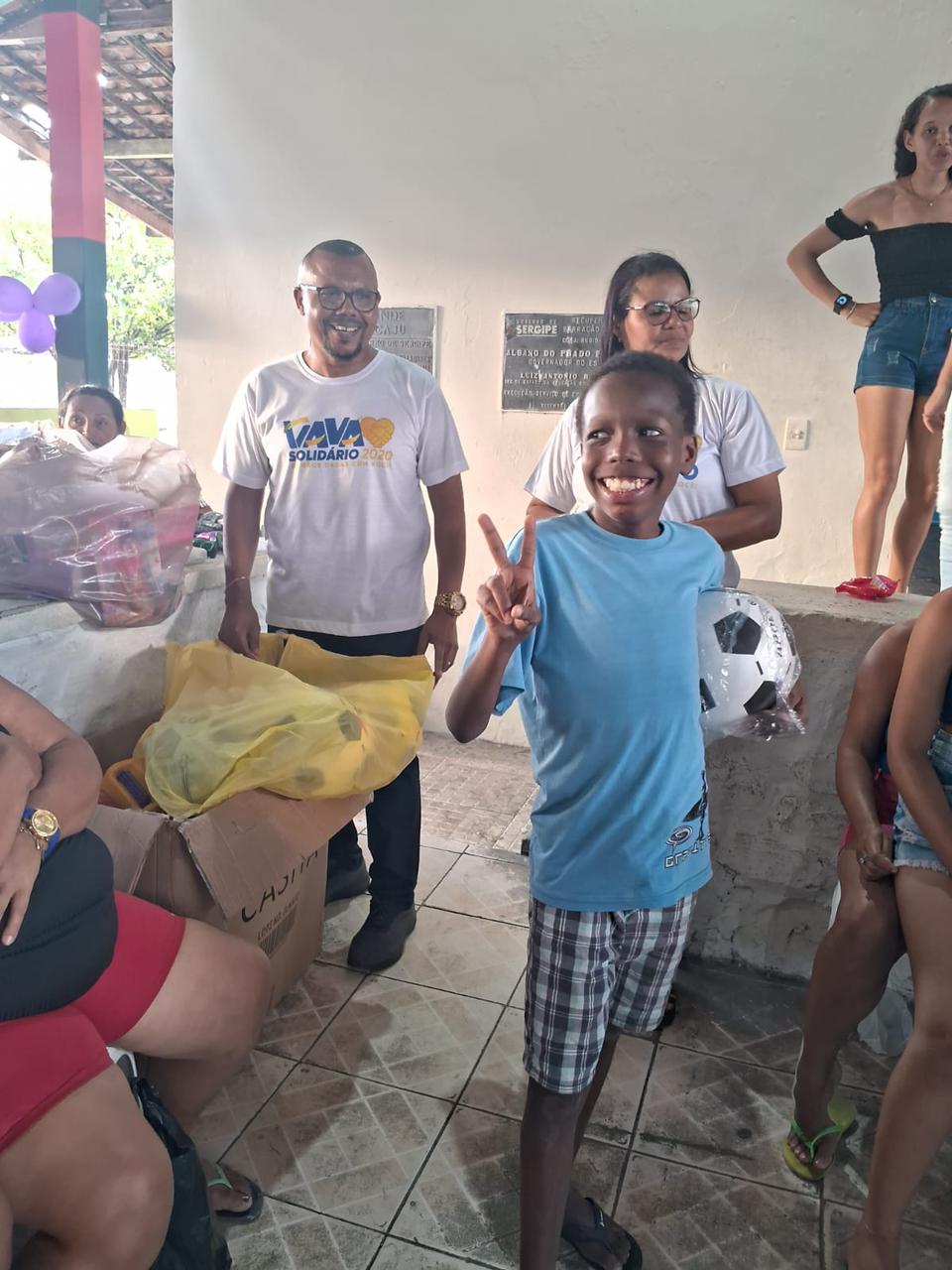 Criança sorri com uma bola recebida na campanha