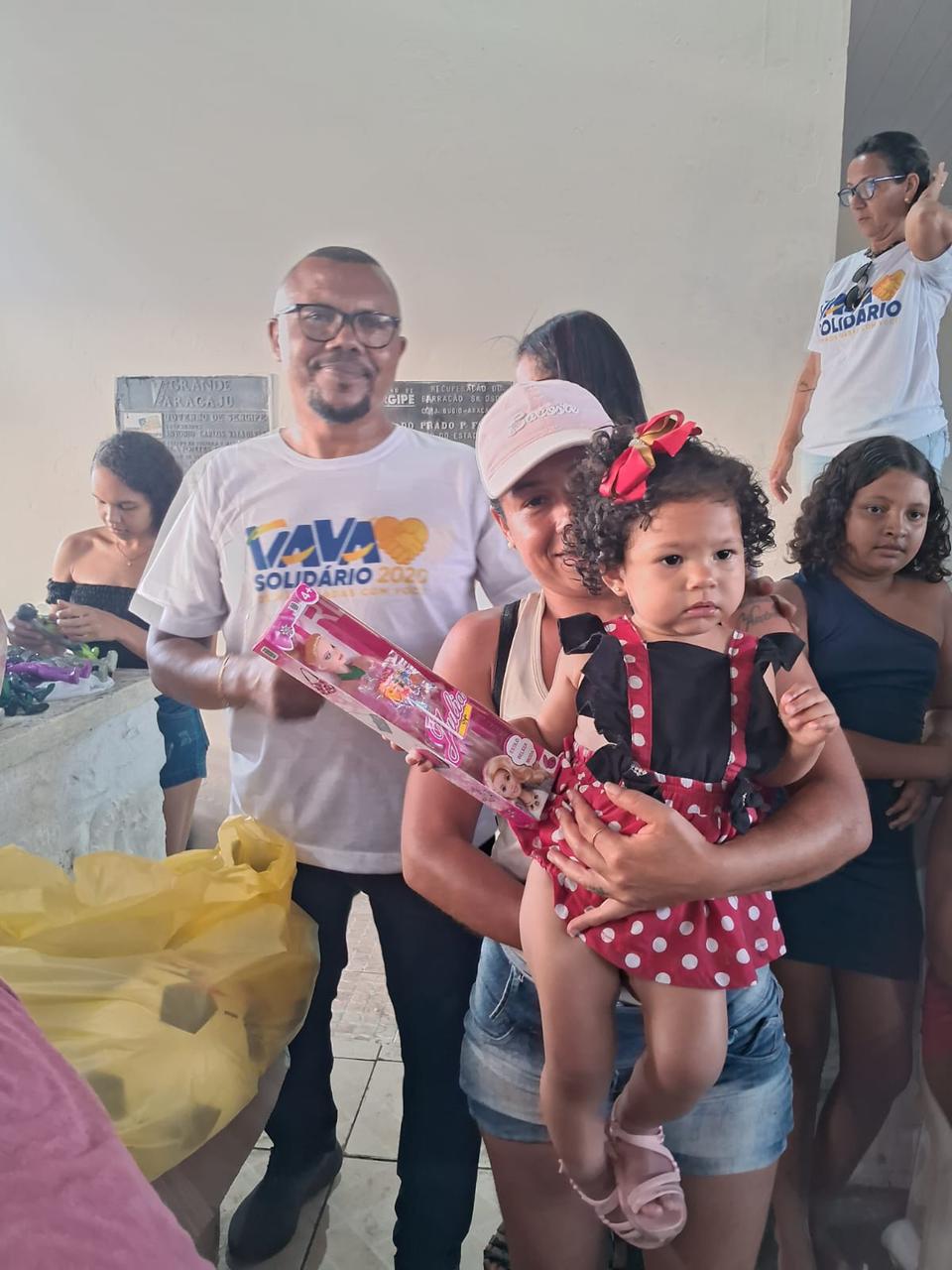 Família posa com uma boneca entregue na campanha