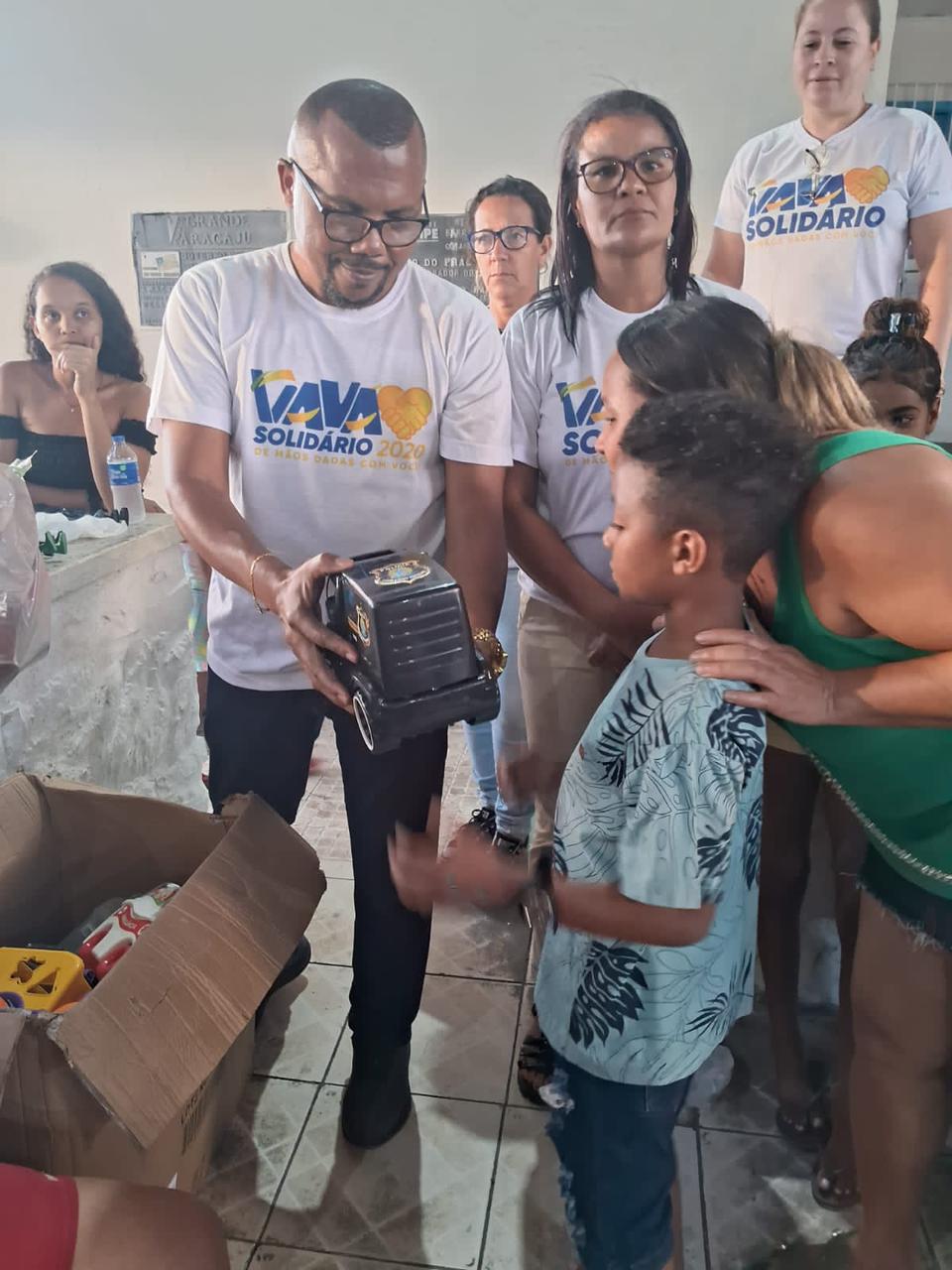 Criança observa um brinquedo entregue por Vavá