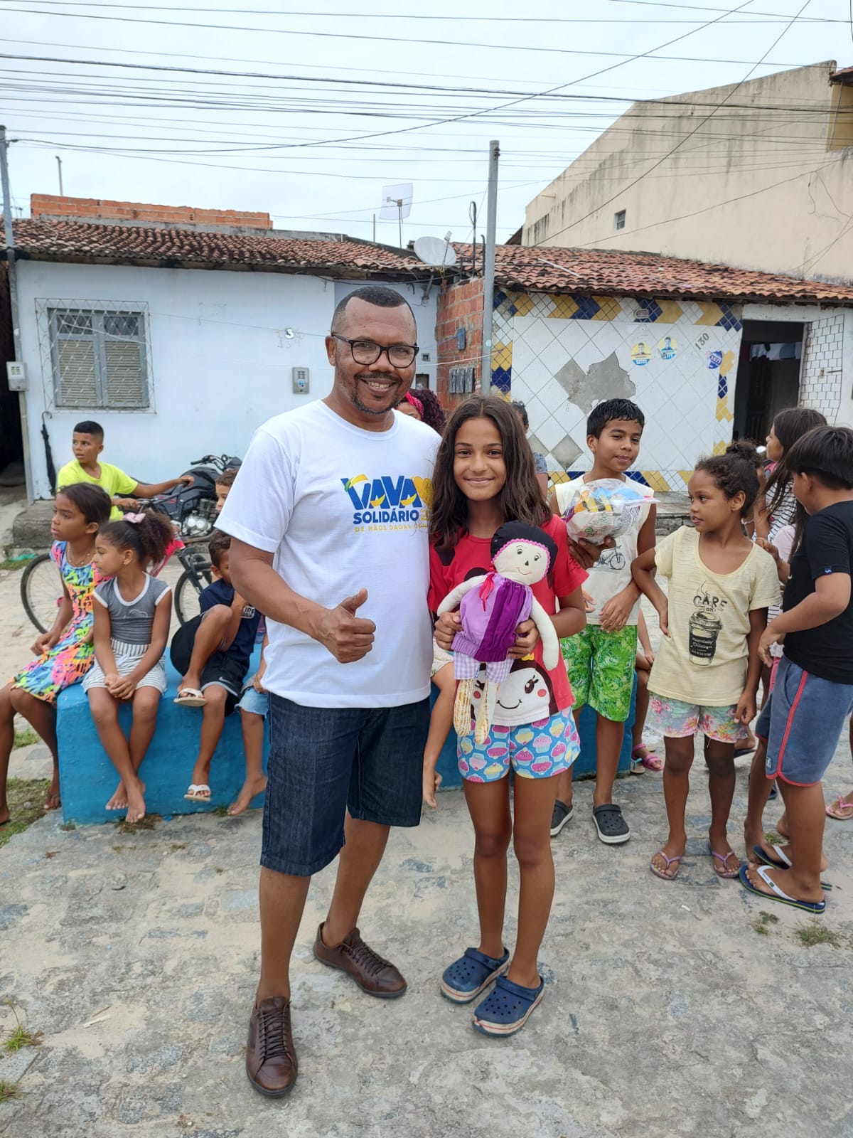 Vavá ao lado de participante da campanha com uma boneca