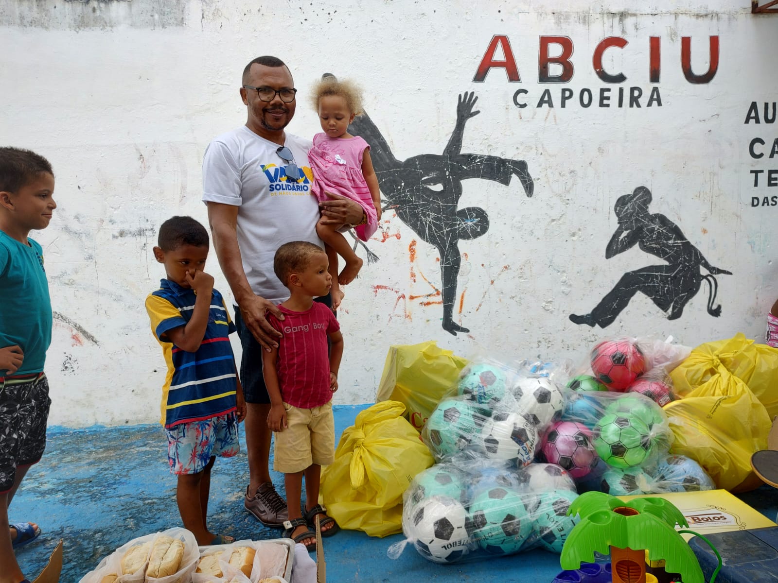 Vavá e crianças junto aos brinquedos da campanha